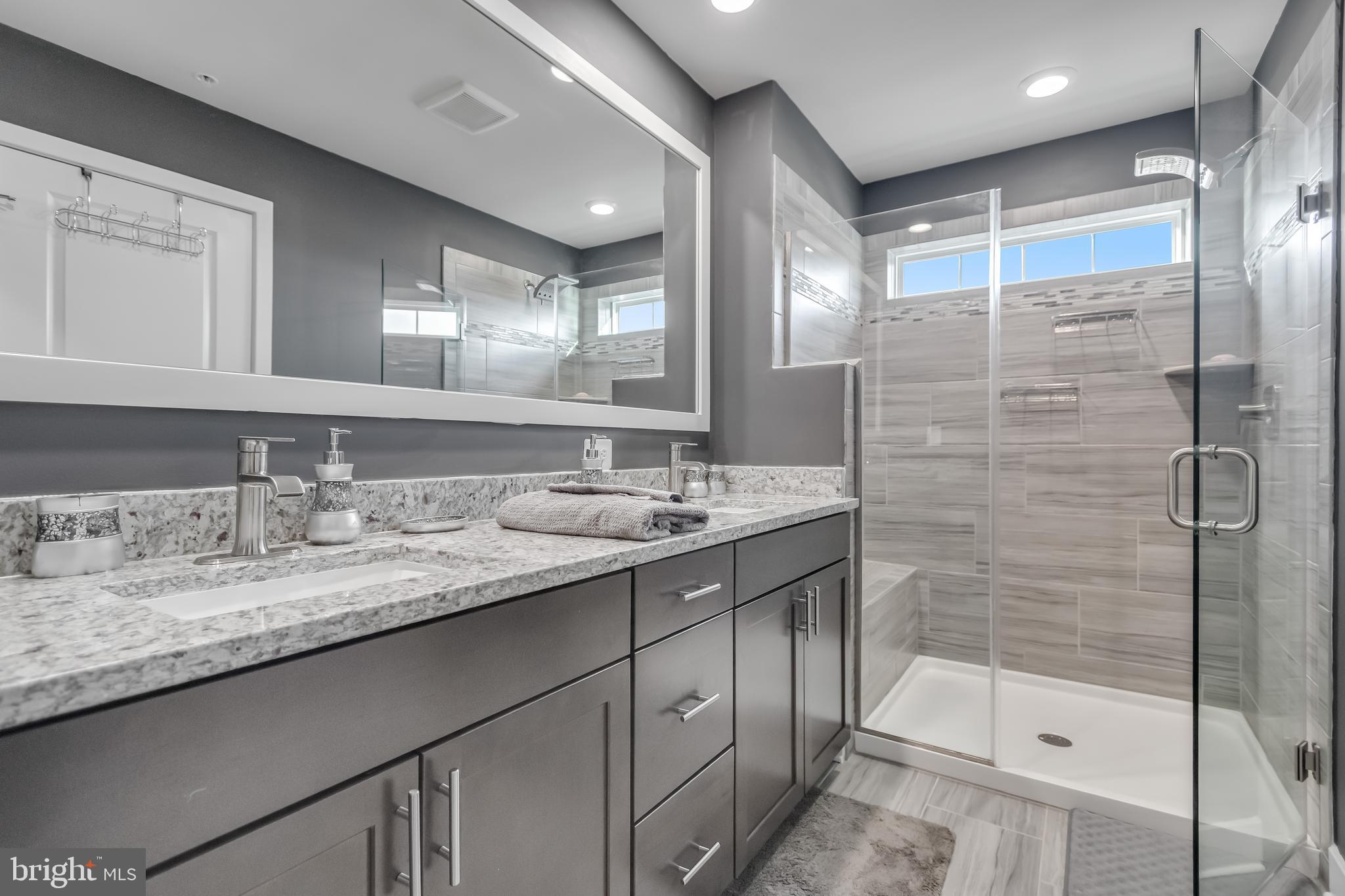 7806 Johnnycake Road Windsor Mill, MD 21244 - Photo 22 of 28 a bathroom with a granite countertop sink a shower and a mirror