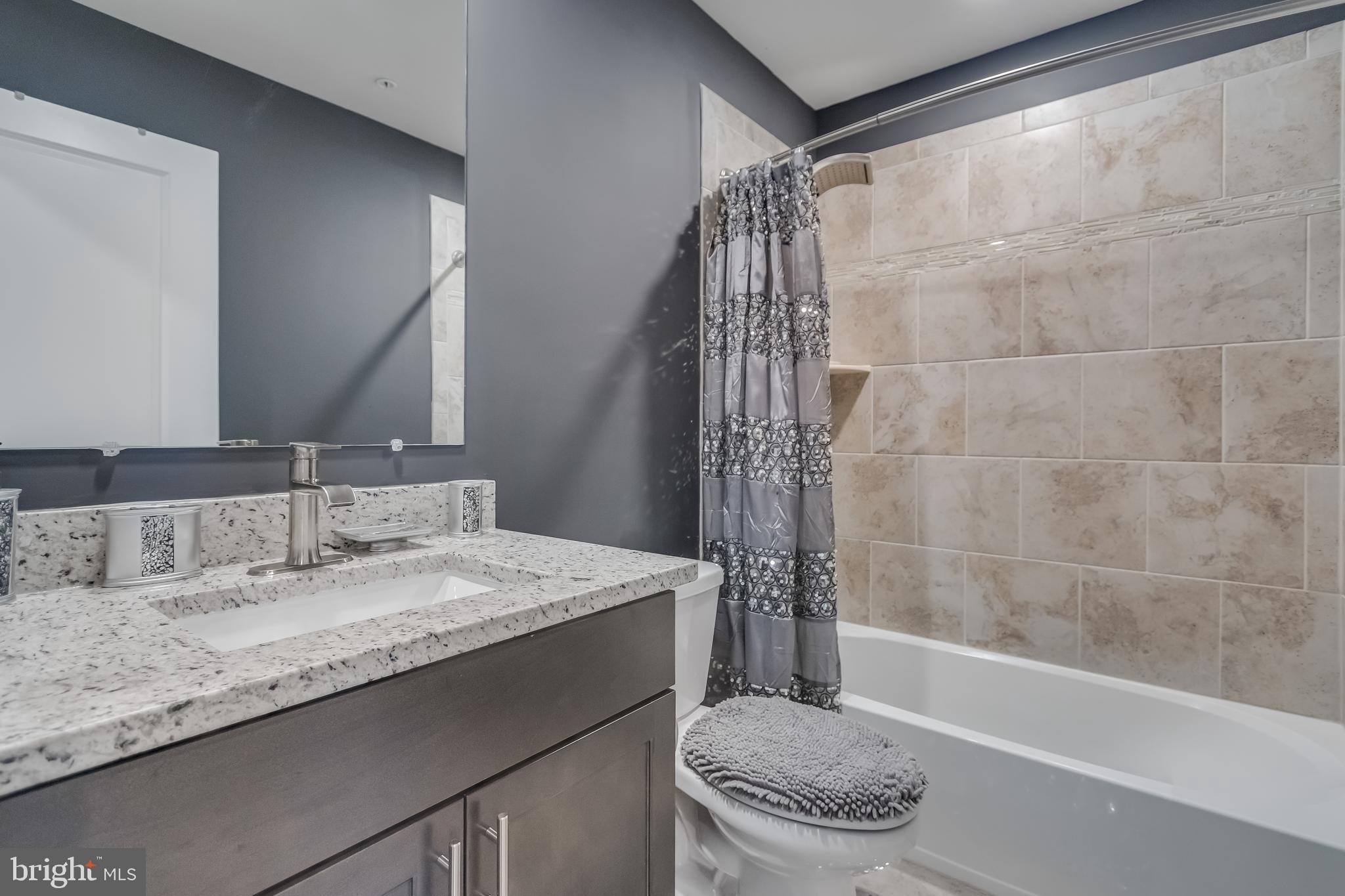 7806 Johnnycake Road Windsor Mill, MD 21244 - Photo 27 of 28 a bathroom with a granite countertop sink a toilet and shower