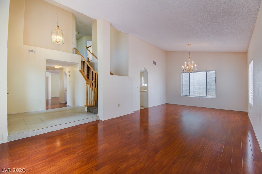 5 Tarryall Terrace Henderson, NV 89074 - Photo 4 of 44 Rich hardwood flooring complements soaring ceilings and an elegant staircase in this inviting living space.