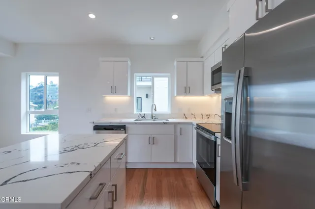 a kitchen with stainless steel appliances granite countertop a sink stove and refrigerator
