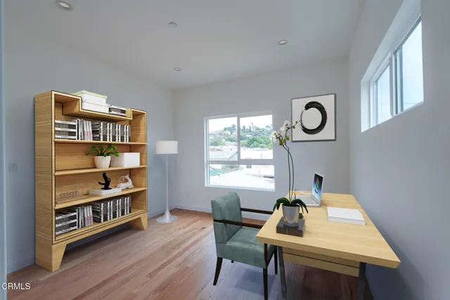 a view of a workspace with furniture and a window