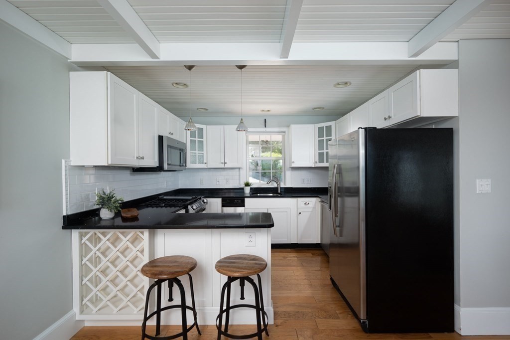 87 Bay Street Hull, MA 02045 - Photo 8 of 25 a kitchen with a refrigerator and a stove top oven