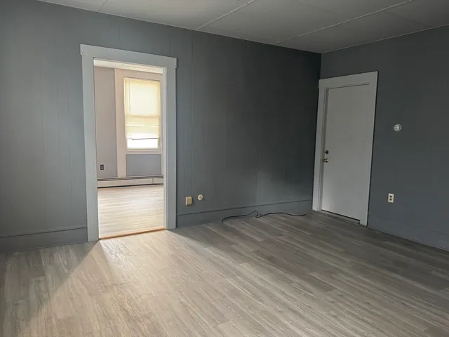 an empty room with wooden floor and closet