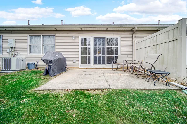 a backyard of a house with table and chairs