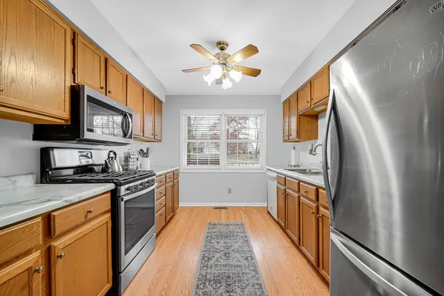 a kitchen with stainless steel appliances granite countertop a refrigerator a stove top oven a sink and dishwasher