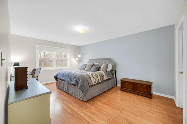 a spacious bedroom with a bed and wooden floor