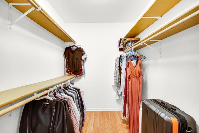 a view of walk in closet with clothes and shoes