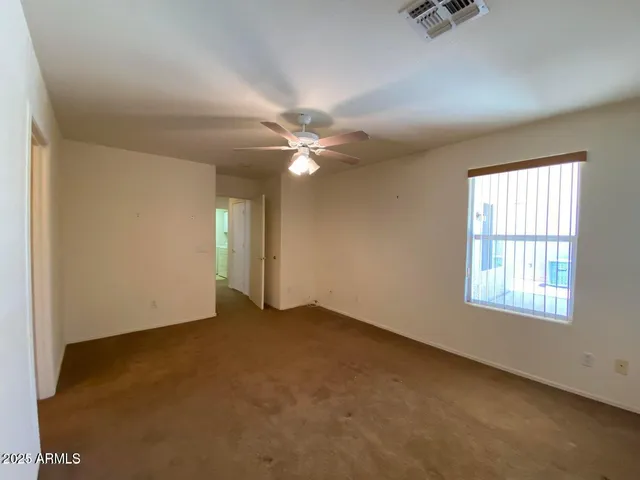 an empty room with windows and fan