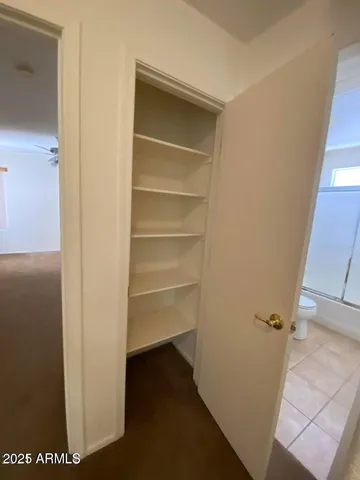 a view of walk in closet with empty racks