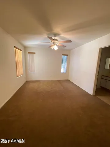 a view of a livingroom with a ceiling fan and window