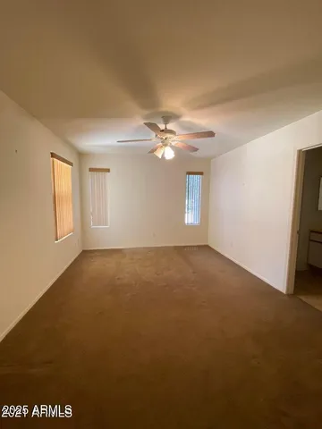 a view of a livingroom with a ceiling fan and window
