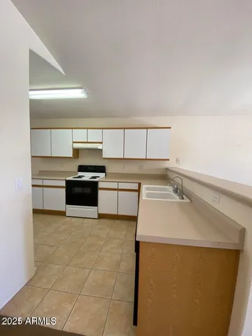 a kitchen with a sink a stove top oven and cabinets