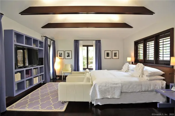 a bedroom with a large bed and a book shelf
