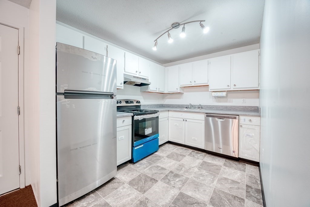 80 Stanton Street, Unit 32 Worcester, MA 01605 - Photo 1 of 21 a kitchen with white cabinets stainless steel appliances and a refrigerator