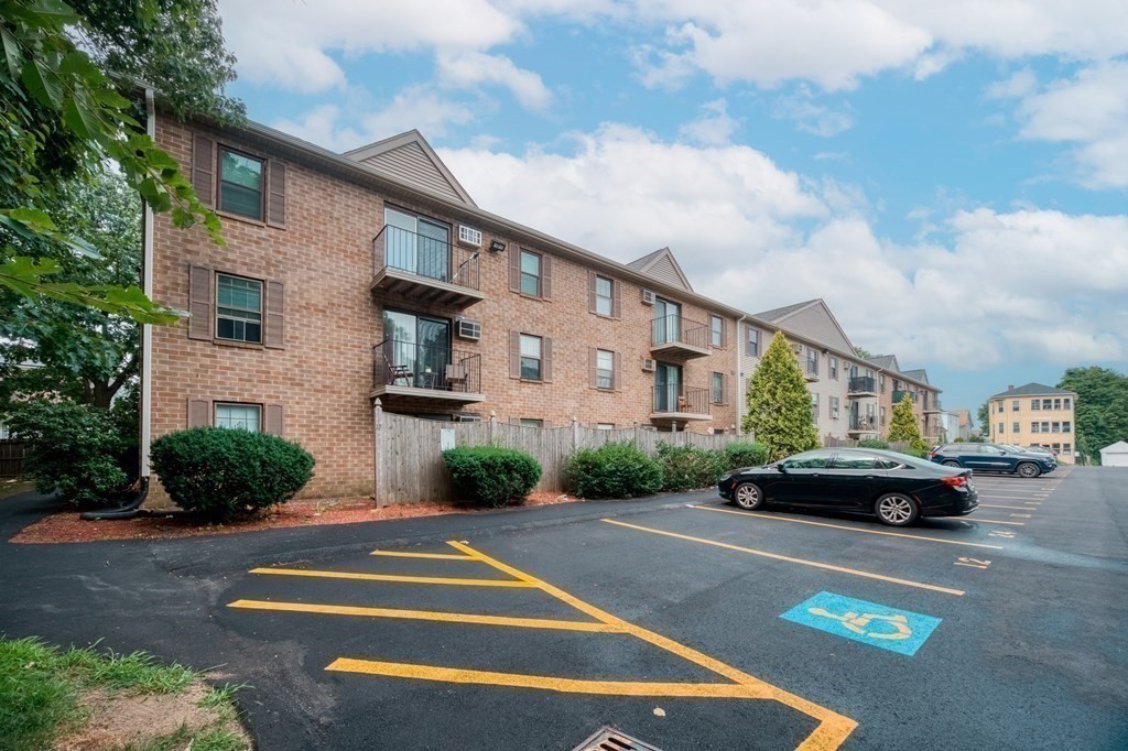 80 Stanton Street, Unit 32 Worcester, MA 01605 - Photo 17 of 21 a front view of a house with a garden and parking