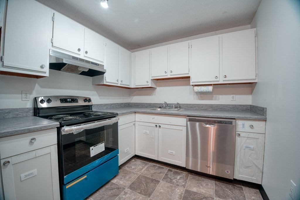 80 Stanton Street, Unit 32 Worcester, MA 01605 - Photo 2 of 21 a kitchen with granite countertop white cabinets stainless steel appliances and sink