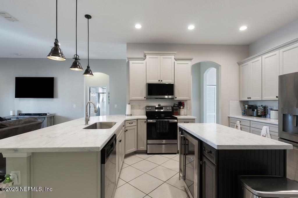 10944 Lothmore Road Jacksonville, FL 32221 - Photo 24 of 85 a kitchen with stainless steel appliances a stove refrigerator sink and microwave