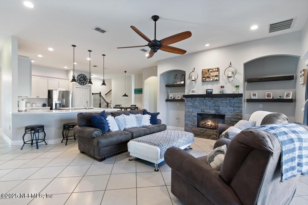 10944 Lothmore Road Jacksonville, FL 32221 - Photo 32 of 85 a living room with furniture a flat screen tv and a fireplace