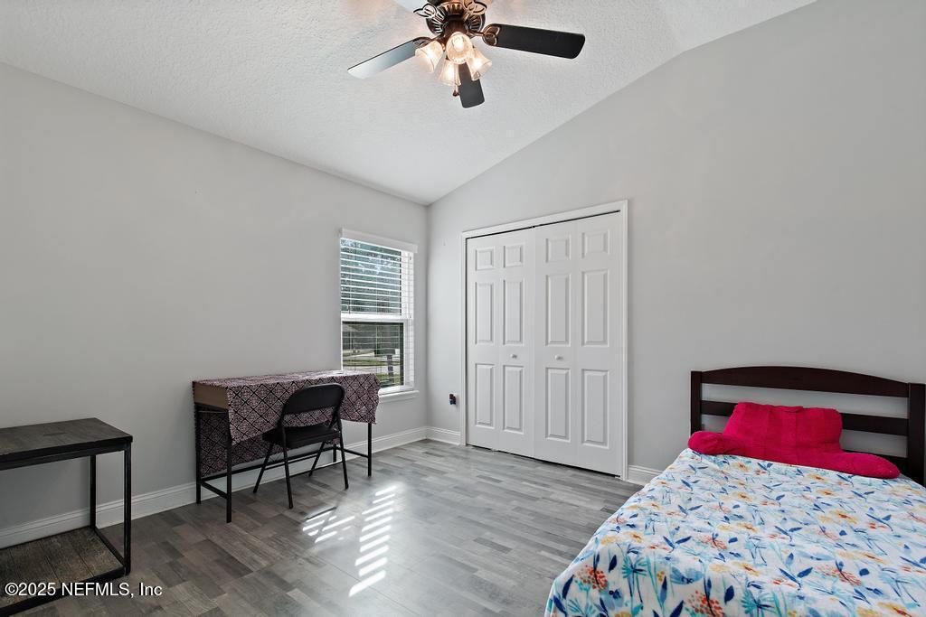 10944 Lothmore Road Jacksonville, FL 32221 - Photo 37 of 85 a bedroom with a bed and a chandelier