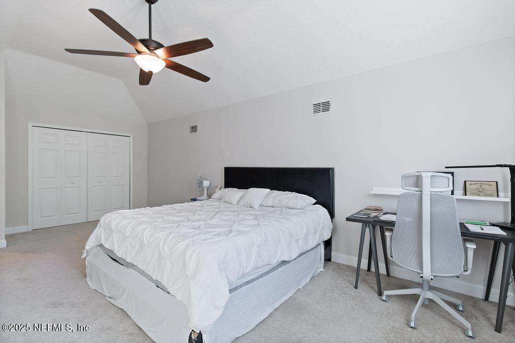 10944 Lothmore Road Jacksonville, FL 32221 - Photo 55 of 85 a bedroom with a bed and a chandelier