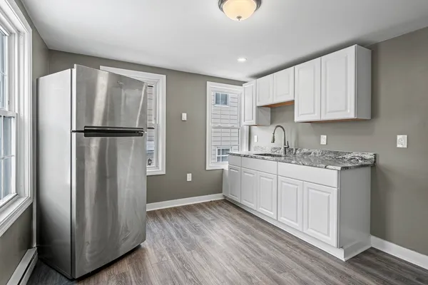 a kitchen with a refrigerator sink and cabinets