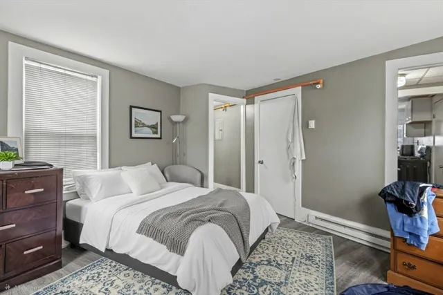 a bedroom with a bed and a mirror on the dresser