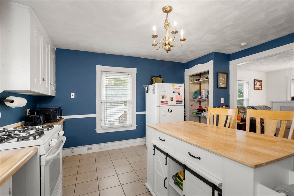 26 Powder Mill Road Maynard, MA 01754 - Photo 6 of 16 a dining room with kitchen island stainless steel appliances furniture a chandelier and a view of kitchen