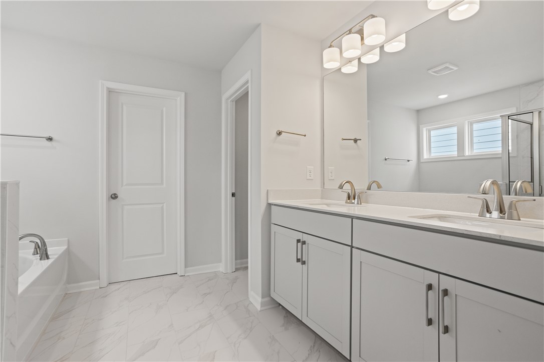555 Hydrangea Street, Unit LOT 47 Seneca, SC 29678 - Photo 24 of 38 Luxurious primary bathroom featuring a spacious double vanity, contemporary fixtures, and a soaking tub.