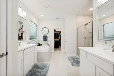 a spacious bathroom with a double vanity sink mirror and shower