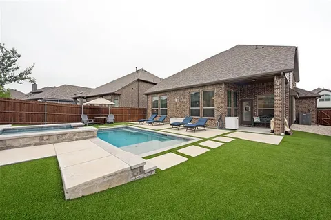 a view of a house with swimming pool and a yard