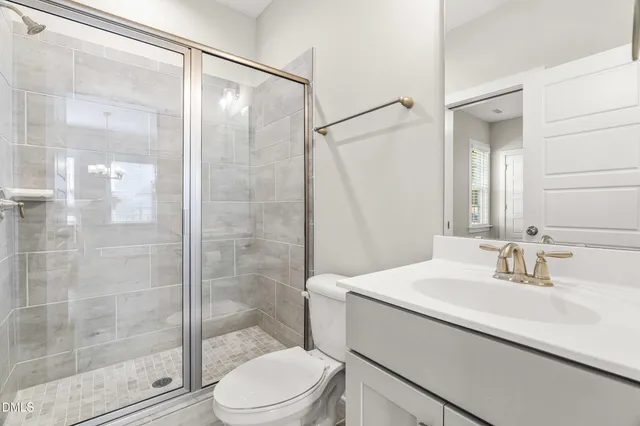 a bathroom with a sink shower and a mirror