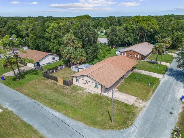 an aerial view of residential houses with outdoor space and trees