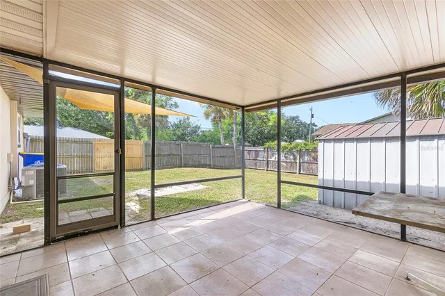 an empty room with kitchen view and window