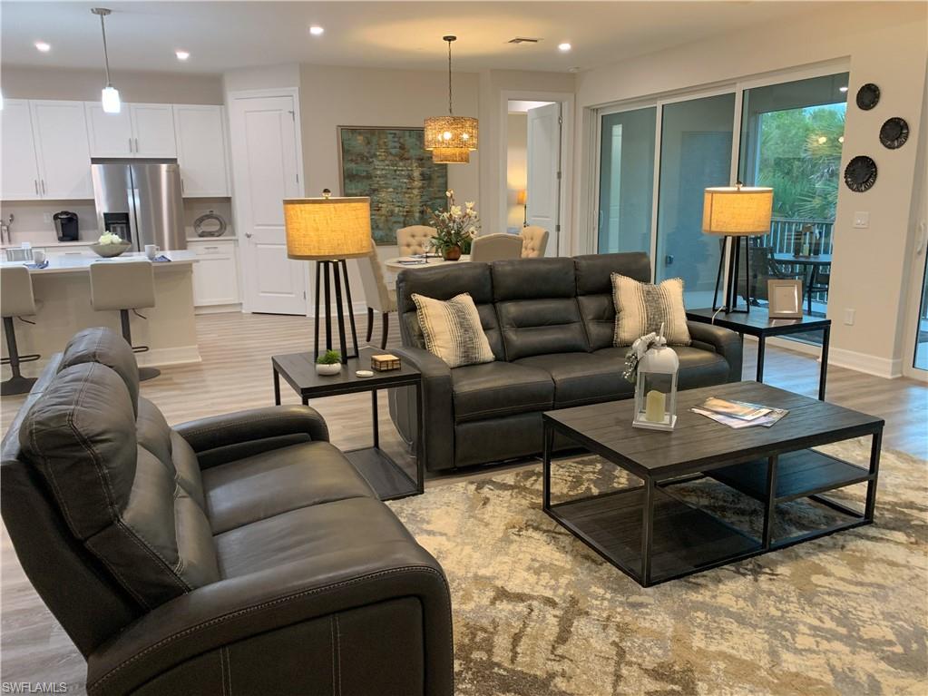 208 Indies Drive East, Unit 202 Naples, FL 34114 - Photo 12 of 48 a living room with furniture and a wooden floor