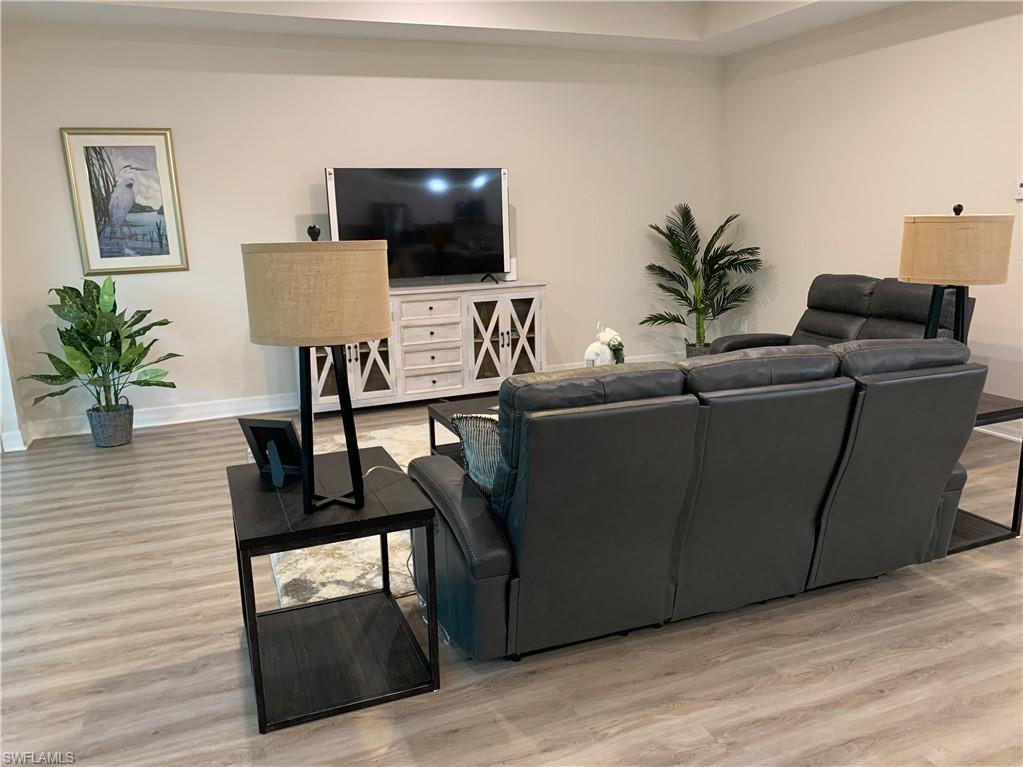 208 Indies Drive East, Unit 202 Naples, FL 34114 - Photo 13 of 48 a living room with furniture and a flat screen tv