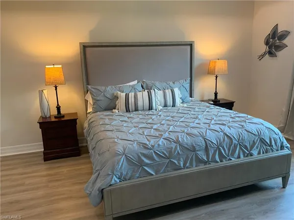 a bed sitting in a bedroom with a lamp