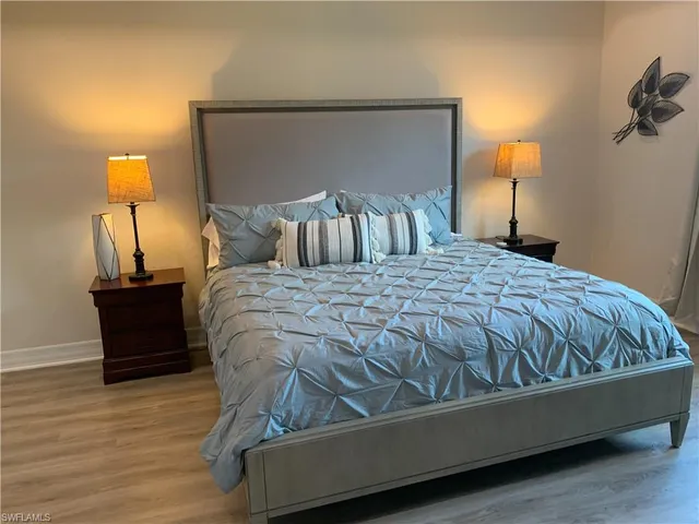 a bed sitting in a bedroom with a lamp