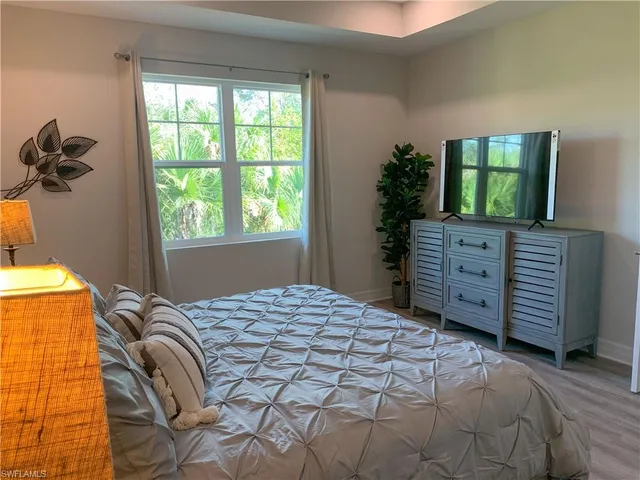 a bedroom with a bed and a flat tv screen