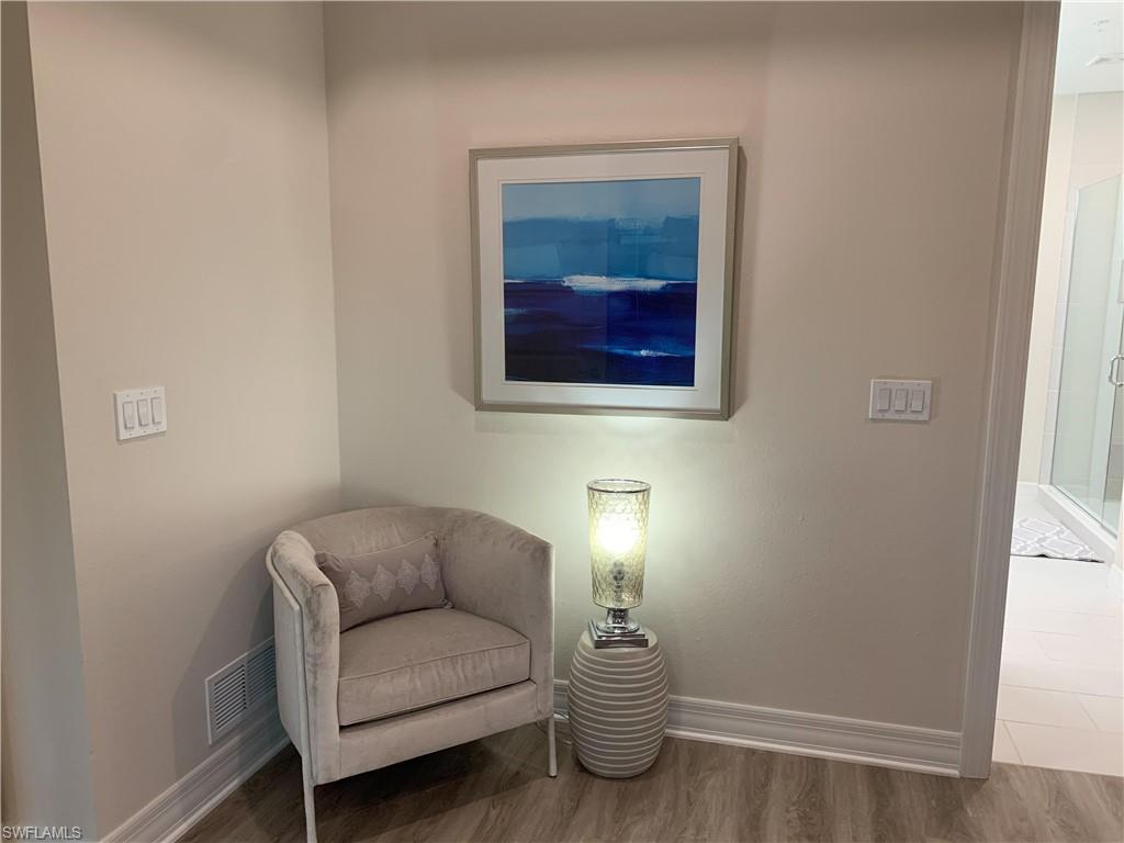 208 Indies Drive East, Unit 202 Naples, FL 34114 - Photo 18 of 48 a living room with furniture and a lamp
