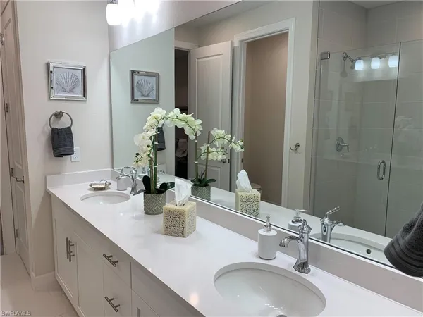 a bathroom with double vanity sinks and a mirror