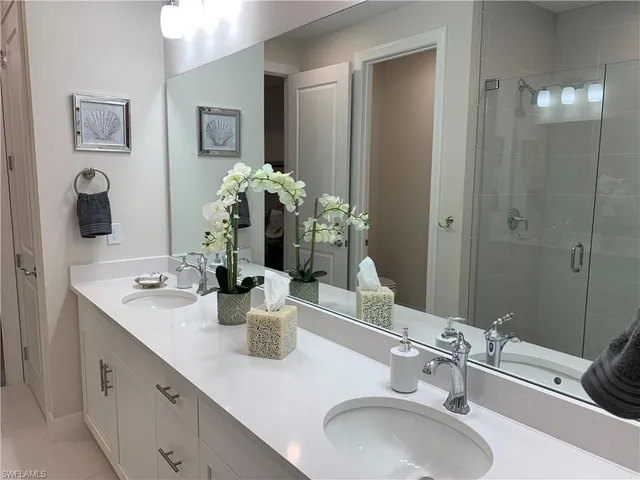 a bathroom with double vanity sinks and a mirror