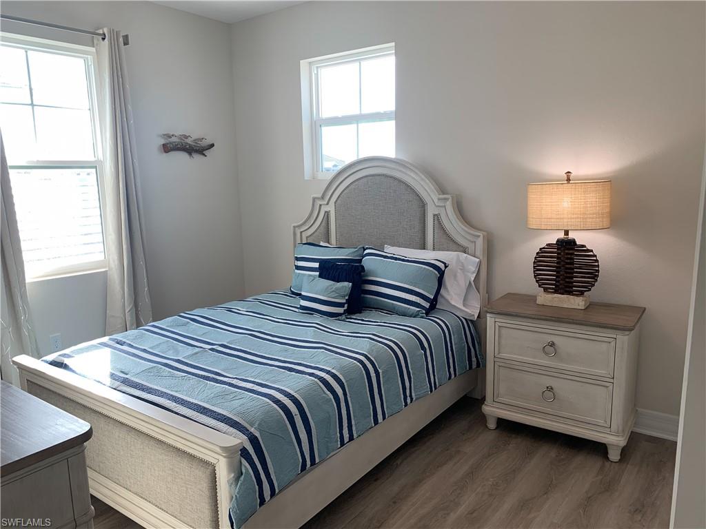 208 Indies Drive East, Unit 202 Naples, FL 34114 - Photo 22 of 48 a bedroom with bed and window