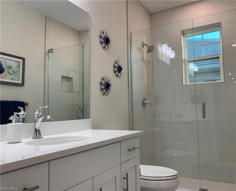 208 Indies Drive East, Unit 202 Naples, FL 34114 - Photo 24 of 48 a bathroom with a granite countertop sink a toilet and shower