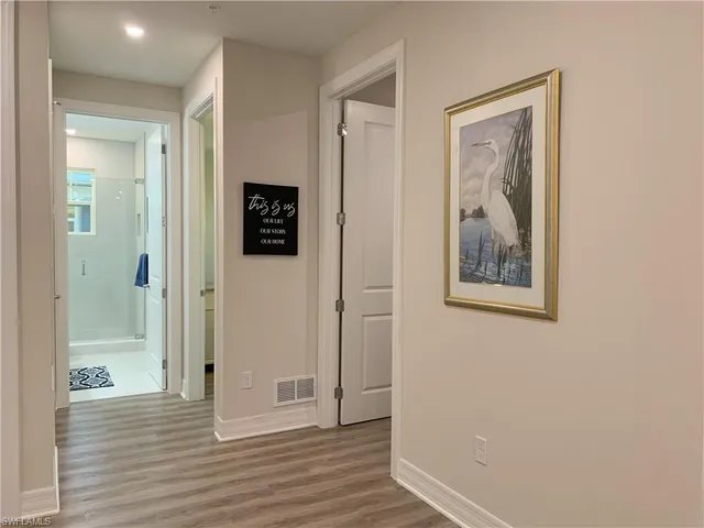 a view of a hallway with wooden floor and closet
