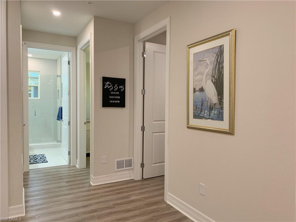 208 Indies Drive East, Unit 202 Naples, FL 34114 - Photo 25 of 48 a view of a hallway with wooden floor and closet