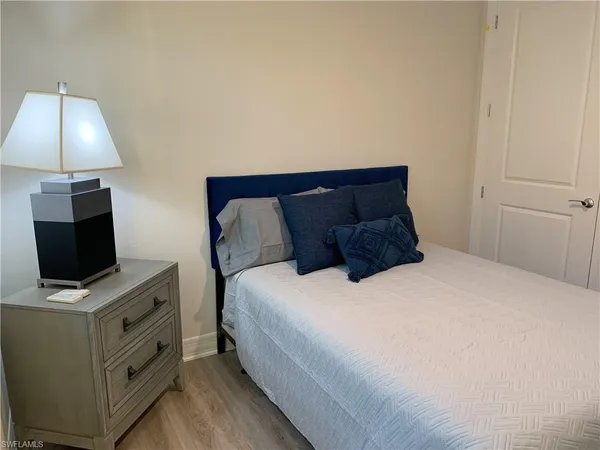 a bedroom with a bed and a flat tv screen on a dresser