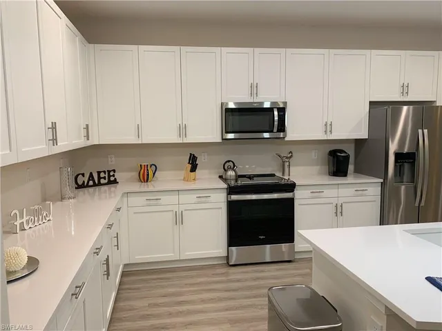 a kitchen with white cabinets and stainless steel appliances