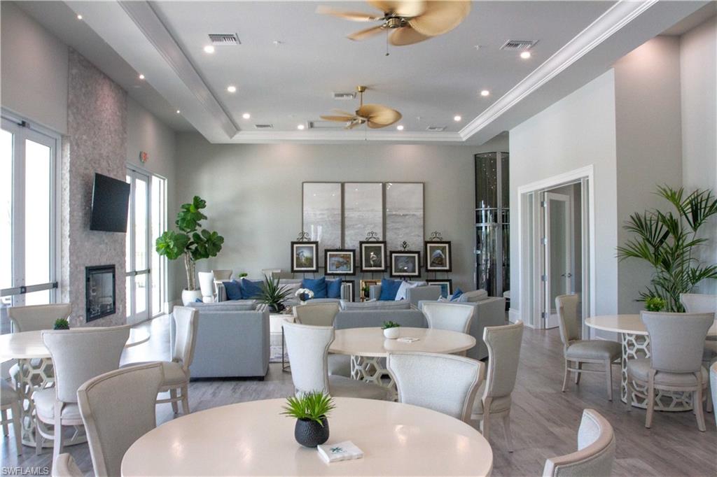 208 Indies Drive East, Unit 202 Naples, FL 34114 - Photo 39 of 48 a living room with furniture potted plant and a chandelier