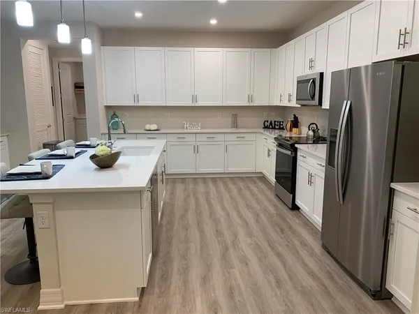 a kitchen with a sink a counter top space stainless steel appliances and cabinets