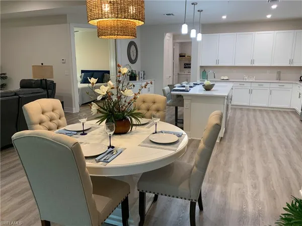 a kitchen with a dining table chairs and white cabinets